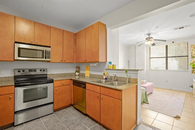 2502 Leon St Unit 102, Austin, TX 78705 - kitchen featuring stainless steel appliances, light tile patterned flooring, ceiling fan, a peninsula, and light countertops