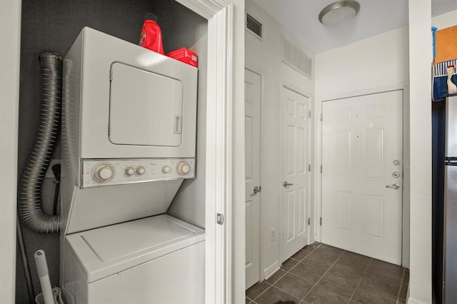 2502 Leon St Unit 102, Austin, TX 78705 - washroom with stacked washer / dryer and dark tile patterned floors