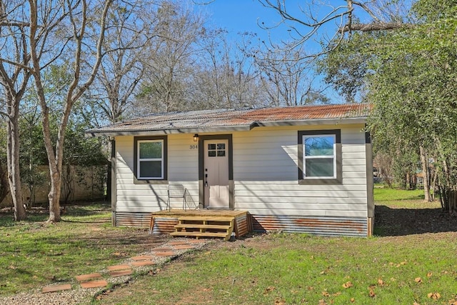 304 Harris St, Smithville, TX 78957 - bungalow-style house with a front lawn and a metal roof