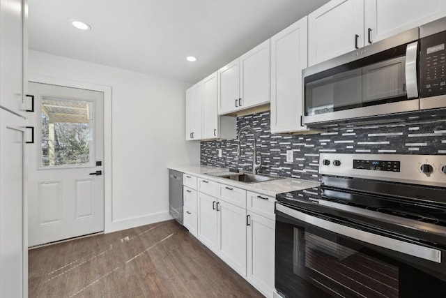 304 Harris St, Smithville, TX 78957 - kitchen featuring appliances with stainless steel finishes, light countertops, backsplash, white cabinetry, and recessed lighting