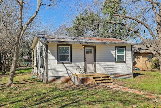 304 Harris St, Smithville, TX 78957 - bungalow-style house with a front yard and a metal roof