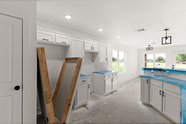 2115 Blackhawk Loop, Belton, TX 76513 - kitchen featuring unfinished concrete flooring, white cabinets, recessed lighting, and hanging light fixtures