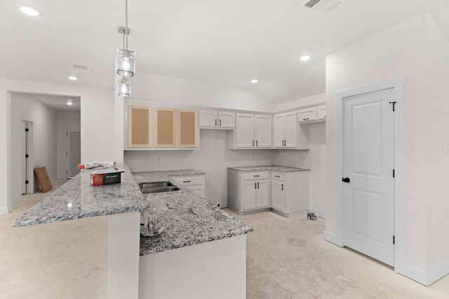 2119 Blackhawk Loop, Belton, TX 76513 - kitchen featuring light stone counters, a peninsula, recessed lighting, hanging light fixtures, and white cabinets