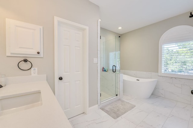 704 Deckhouse Dr, Lago Vista, TX 78645 - bathroom featuring marble look tiles, a marble finish shower, a freestanding bath, recessed lighting, and vanity