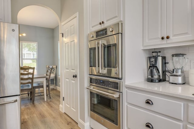 704 Deckhouse Dr, Lago Vista, TX 78645 - kitchen with appliances with stainless steel finishes, white cabinets, tasteful backsplash, and light stone counters
