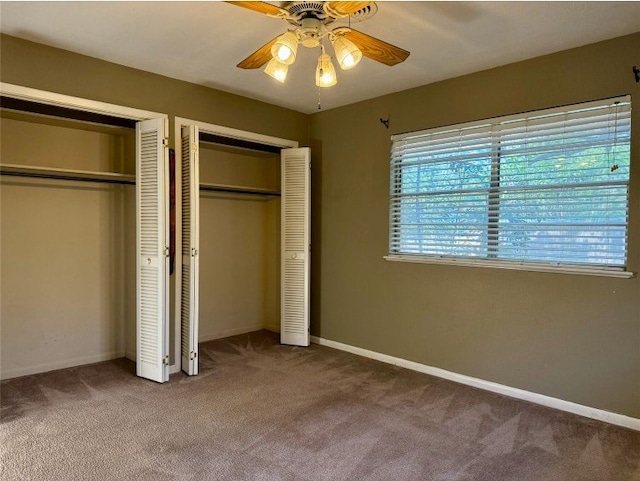 11601 Oak Trl, Austin, TX 78753 - unfurnished bedroom with two closets, carpet flooring, and a ceiling fan