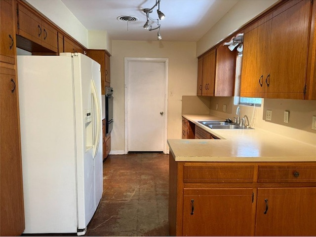 11601 Oak Trl, Austin, TX 78753 - kitchen featuring white refrigerator with ice dispenser, light countertops, and brown cabinets