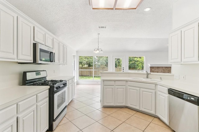 800 Mountain Ridge Dr, Leander, TX 78641 - kitchen with appliances with stainless steel finishes, a textured ceiling, light countertops, white cabinets, and light tile patterned floors