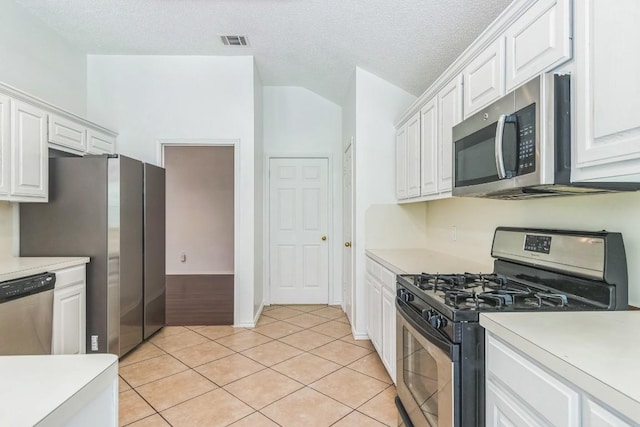 800 Mountain Ridge Dr, Leander, TX 78641 - kitchen with stainless steel appliances, light countertops, white cabinetry, light tile patterned floors, and a textured ceiling