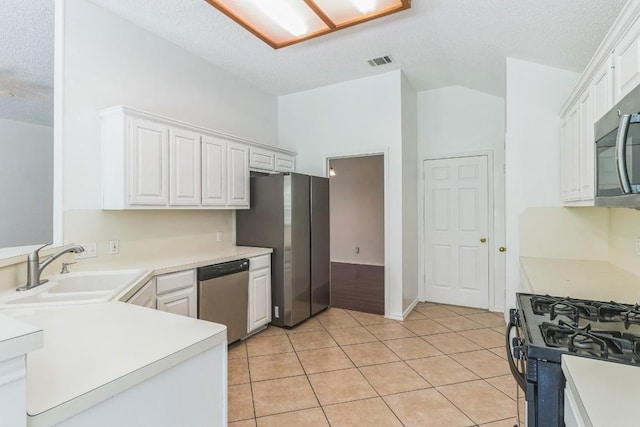 800 Mountain Ridge Dr, Leander, TX 78641 - kitchen featuring stainless steel appliances, light tile patterned flooring, white cabinets, light countertops, and lofted ceiling