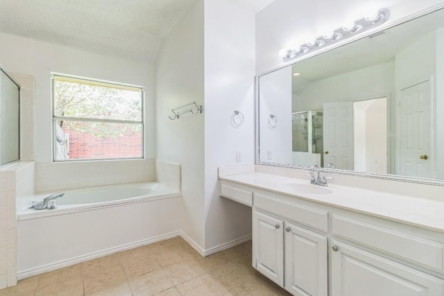 800 Mountain Ridge Dr, Leander, TX 78641 - bathroom featuring a garden tub, vanity, tile patterned floors, and a textured ceiling