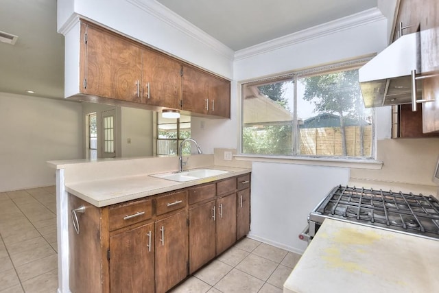 803 Easy Day Cv, Austin, TX 78745 - kitchen featuring light tile patterned floors, light countertops, stainless steel gas range, exhaust hood, and crown molding