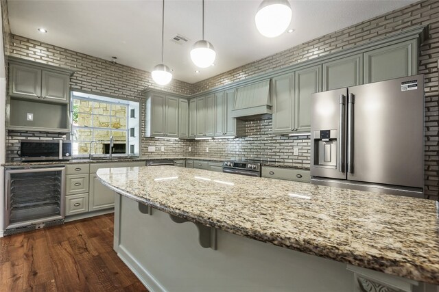 1708 Shag Bark Trl, Austin, TX 78758 - kitchen with stainless steel fridge with ice dispenser, wine cooler, custom range hood, light stone counters, and gray cabinetry