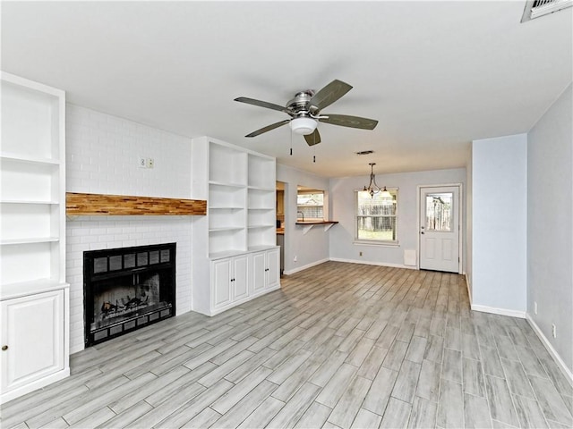 1708 Shag Bark Trl, Austin, TX 78758 - unfurnished living room with ceiling fan, light wood-style floors, a fireplace, and a chandelier