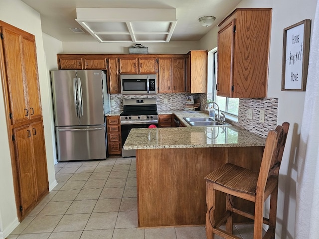 1202 Bowen Ave, Copperas Cove, TX 76522 - kitchen with appliances with stainless steel finishes, a peninsula, backsplash, and brown cabinets