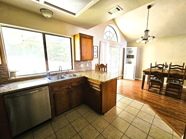 1202 Bowen Ave, Copperas Cove, TX 76522 - kitchen with dishwasher, dark tile patterned floors, lofted ceiling, backsplash, and plenty of natural light