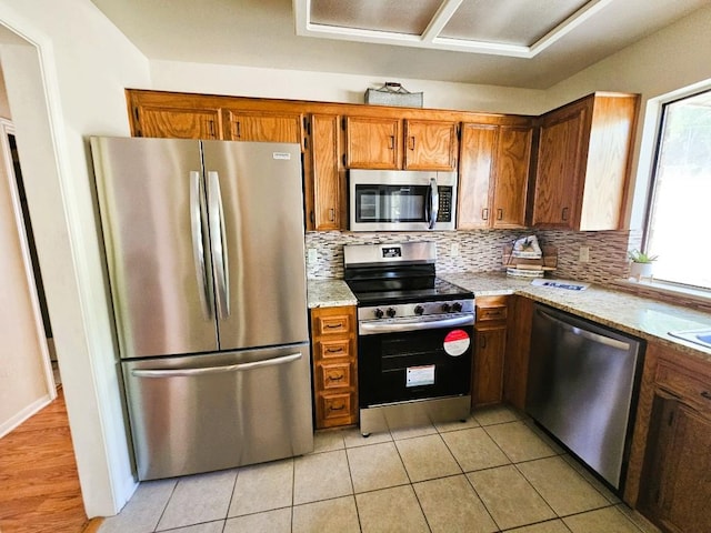 1202 Bowen Ave, Copperas Cove, TX 76522 - kitchen featuring stainless steel appliances, brown cabinets, decorative backsplash, and light tile patterned flooring