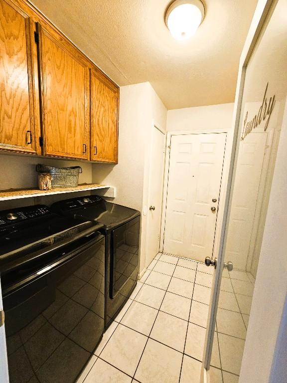 1202 Bowen Ave, Copperas Cove, TX 76522 - laundry area featuring independent washer and dryer, cabinet space, and light tile patterned flooring