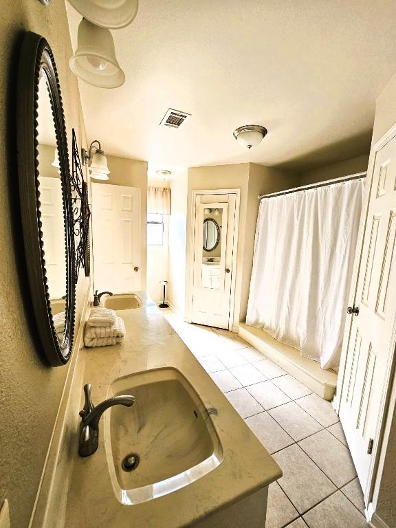 1202 Bowen Ave, Copperas Cove, TX 76522 - bathroom with tile patterned floors, double vanity, and a shower with shower curtain