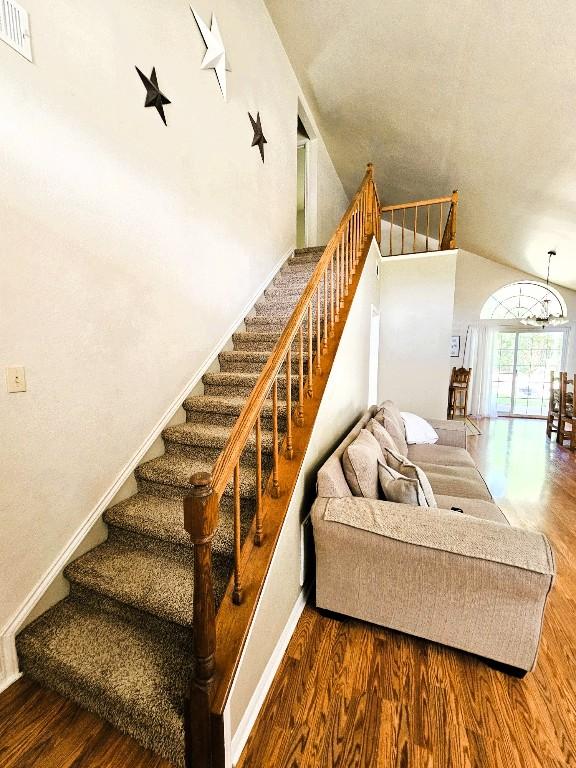 1202 Bowen Ave, Copperas Cove, TX 76522 - stairway with wood finished floors, high vaulted ceiling, and a chandelier
