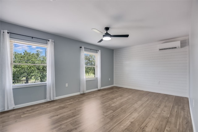3112 Oak Ridge Dr, Horseshoe Bay, TX 78657 - unfurnished room with a wall mounted AC, wood finished floors, a ceiling fan, and wooden walls