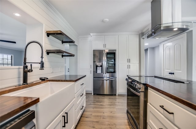 3112 Oak Ridge Dr, Horseshoe Bay, TX 78657 - kitchen featuring stainless steel appliances, island range hood, light wood-type flooring, and white cabinetry
