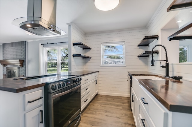 3112 Oak Ridge Dr, Horseshoe Bay, TX 78657 - kitchen featuring open shelves, stainless steel electric range oven, butcher block counters, island range hood, and ornamental molding