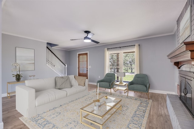 3112 Oak Ridge Dr, Horseshoe Bay, TX 78657 - living area featuring a fireplace, stairs, ceiling fan, ornamental molding, and wood finished floors