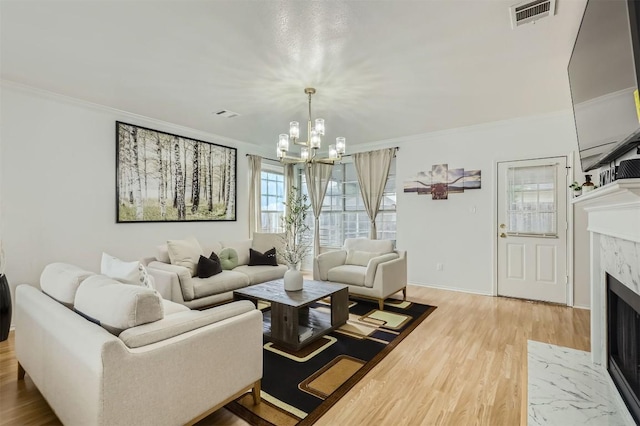 1016 Thackeray Ln, Pflugerville, TX 78660 - living area featuring a fireplace, ornamental molding, light wood-style flooring, and a chandelier