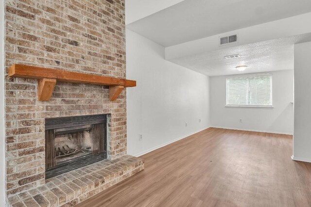 9611 Meadowheath Dr, Austin, TX 78729 - unfurnished living room featuring wood finished floors and a fireplace