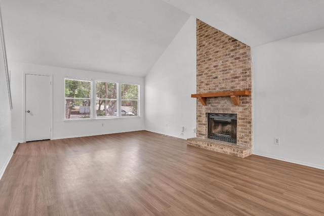 9611 Meadowheath Dr, Austin, TX 78729 - unfurnished living room featuring wood finished floors, a brick fireplace, and high vaulted ceiling