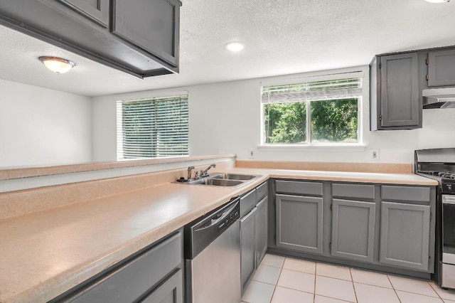 9611 Meadowheath Dr, Austin, TX 78729 - kitchen featuring appliances with stainless steel finishes, gray cabinets, under cabinet range hood, and a textured ceiling