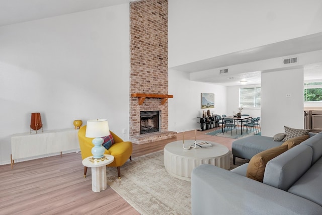9611 Meadowheath Dr, Austin, TX 78729 - living room with wood finished floors, radiator, a towering ceiling, and a brick fireplace
