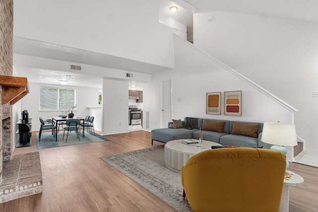 9611 Meadowheath Dr, Austin, TX 78729 - living room featuring a fireplace, light wood-style flooring, and a high ceiling