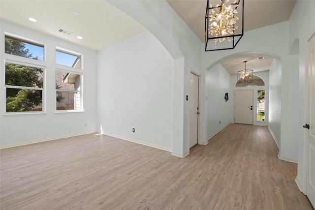 4204 Pasada Ln, Round Rock, TX 78681 - unfurnished room with a chandelier, arched walkways, and light wood-style flooring