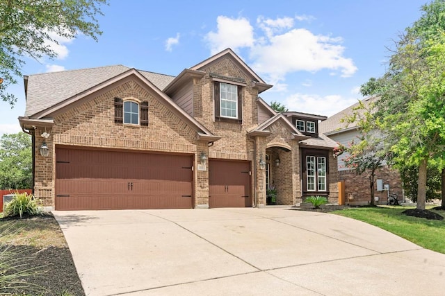 112 Florenz Ln, Georgetown, TX 78628 - view of front of house featuring brick siding, concrete driveway, roof with shingles, and an attached garage