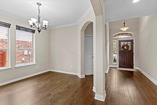 112 Florenz Ln, Georgetown, TX 78628 - entryway with dark wood-style flooring, a chandelier, arched walkways, and ornamental molding