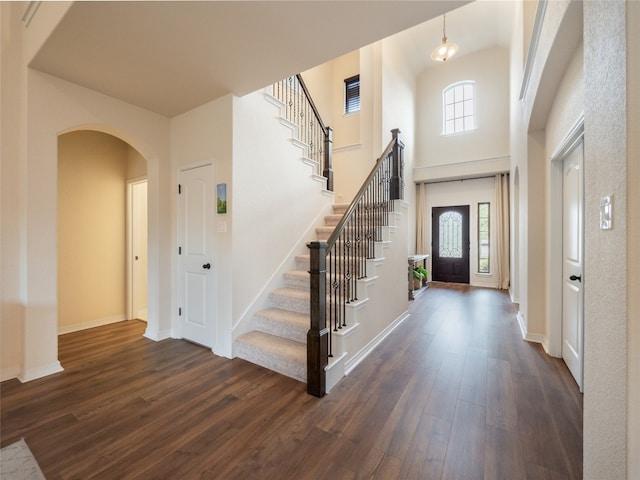 22617 Fountaingrass Ln, Lago Vista, TX 78645 - foyer featuring dark wood finished floors, stairs, arched walkways, and a high ceiling