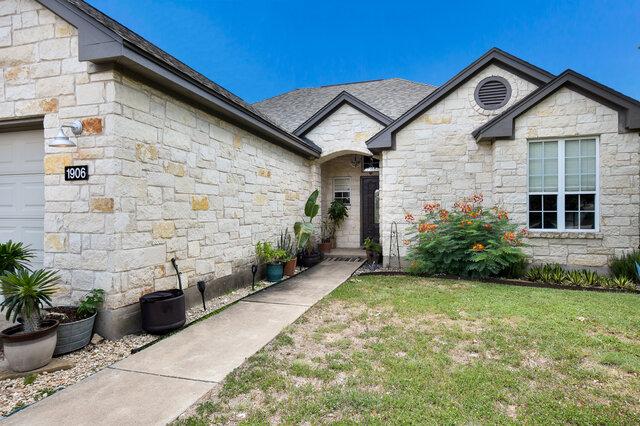 1906 W Moeta Dr, Austin, TX 78734 - view of front facade featuring stone siding and a front yard