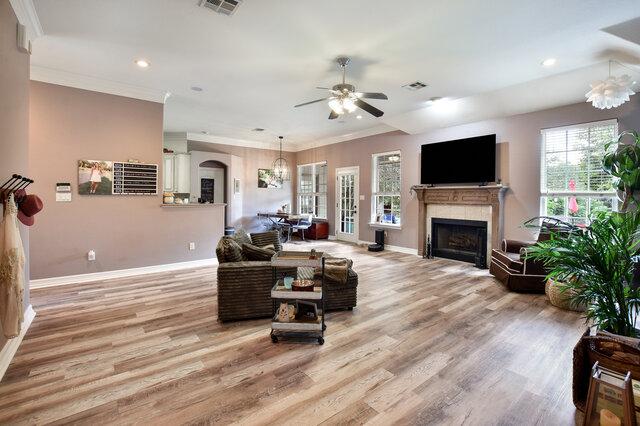 1906 W Moeta Dr, Austin, TX 78734 - living room featuring a fireplace, ceiling fan, crown molding, light wood-style floors, and recessed lighting