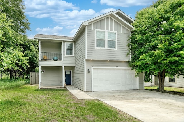 125 Hawea Ln, Bastrop, TX 78602 - view of front of home with a balcony, an attached garage, concrete driveway, a front lawn, and board and batten siding