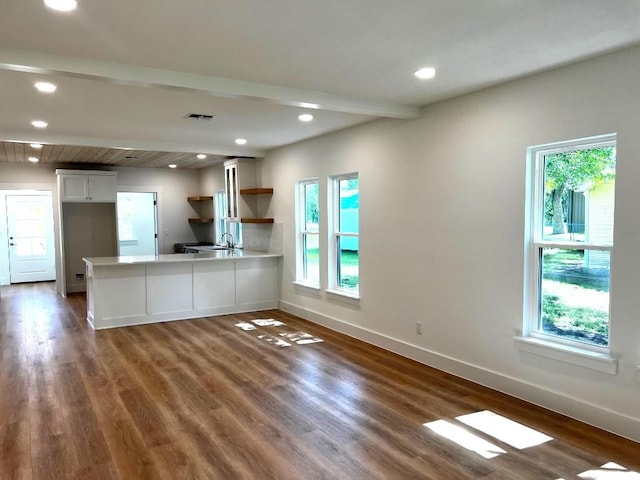 1105 Carroll Ln, La Grange, TX 78945 - unfurnished living room featuring beamed ceiling, dark wood-style floors, healthy amount of natural light, and recessed lighting