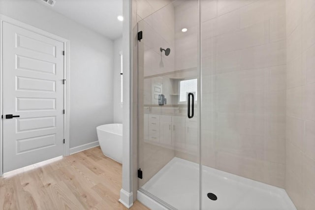 17224 Autumn Falls Dr, Manor, TX 78653 - full bath featuring a stall shower, wood finished floors, and a freestanding tub