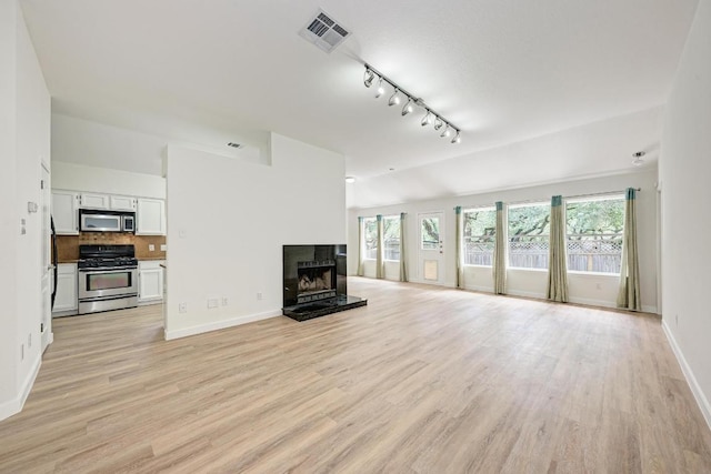 2705 Sabinal Trl, Cedar Park, TX 78613 - unfurnished living room with plenty of natural light, light wood finished floors, and track lighting