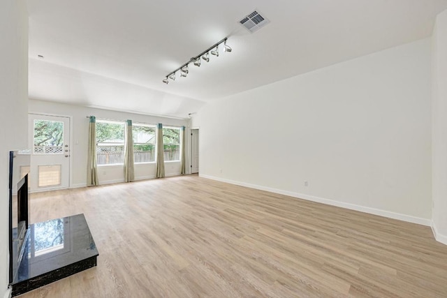 2705 Sabinal Trl, Cedar Park, TX 78613 - unfurnished living room featuring rail lighting, light wood-style flooring, and lofted ceiling