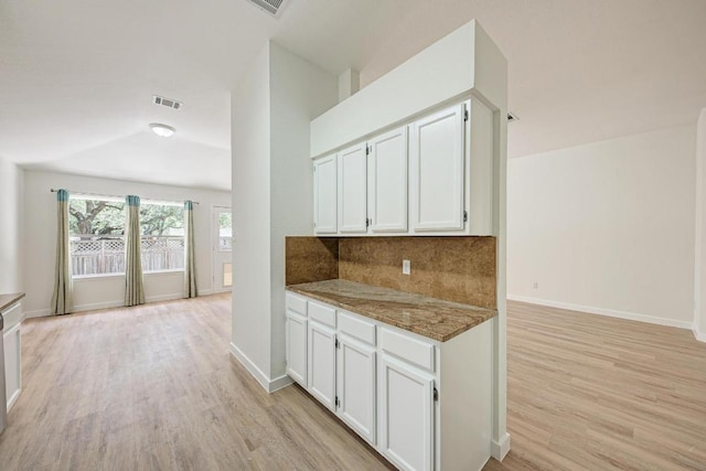 2705 Sabinal Trl, Cedar Park, TX 78613 - kitchen with light wood-style floors, tasteful backsplash, white cabinets, and light stone counters