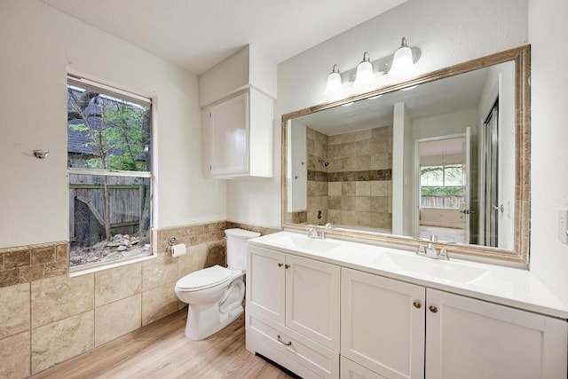 2705 Sabinal Trl, Cedar Park, TX 78613 - full bathroom featuring tile walls, plenty of natural light, double vanity, wainscoting, and wood finished floors