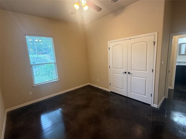 208 Akaloa Dr, Bastrop, TX 78602 - unfurnished bedroom featuring concrete flooring, a closet, and a ceiling fan