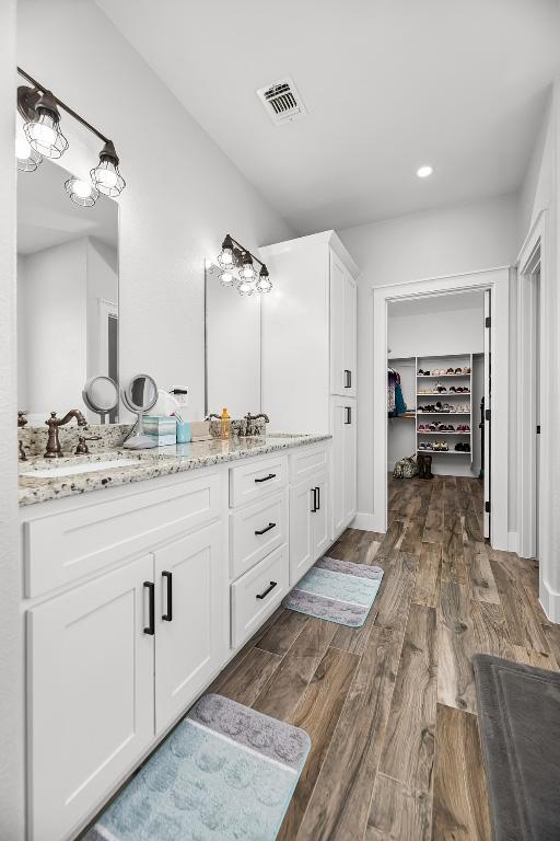 110 Les Ln, Smithville, TX 78957 - full bathroom with vanity, wood finished floors, a spacious closet, and recessed lighting