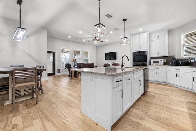 110 Les Ln, Smithville, TX 78957 - kitchen featuring oven, light wood-style flooring, recessed lighting, white microwave, and light stone counters
